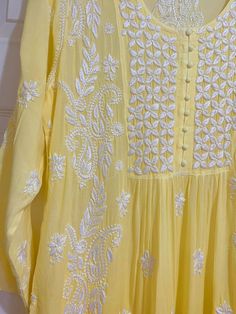 This Women's Yellow Gold Muslin Silk Handcrafted Lucknowi Chikankari A Line Kurta Long Dress is a stunning piece of art. The beautiful yellow gold color is perfect for any special occasion. The luxurious fabric and intricate embroidery make it a timeless piece that will never go out of style. 48" length Long sleeves 18" Round neck Muslin silk Chikankari embroidery Hand embroidered Dry Clean Fit: True to sizeInside Margin: NoTouch and Feel: Soft and ComfortableDispatched in 1-3 business days Luxury Chikankari Embroidered Fabric For Women, Transitional Yellow Anarkali Set With Long Sleeves, Yellow Long Sleeve Anarkali Set For Transitional Season, Transitional Yellow Long Sleeve Anarkali Set, Yellow Mulmul Anarkali Set For Diwali, Yellow Bollywood Anarkali Set In Mulmul, Yellow Anarkali Set With Chikankari Embroidery, Straight Kurta, Yellow Mulmul Anarkali Set With Straight Kurta, Yellow Straight Kurta Anarkali Set With Chikankari Embroidery