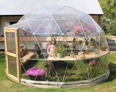 a woman sitting in a greenhouse with potted plants inside