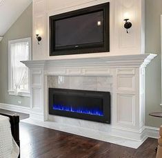 a white fireplace with a flat screen tv above it