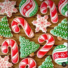 decorated christmas cookies and candy canes on a wooden table