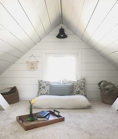 a bed sitting in the middle of a room under a slanted ceiling next to a window