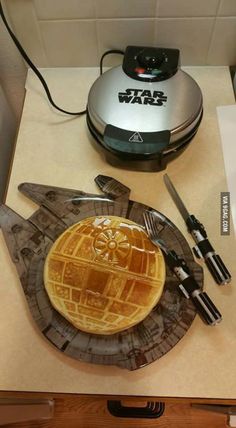 a star wars themed waffle plate next to a toaster and utensils