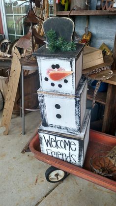 a snowman made out of crates sitting on top of a floor next to a chair