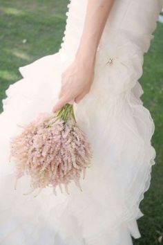 a woman in a white dress holding a bouquet of flowers