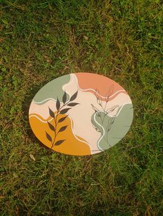 a frisbee laying in the grass with leaves on it