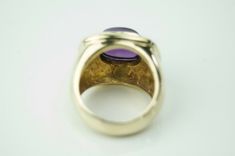 Beautiful amethyst cocktail ring! The stunning deep purple bezeled cabochon stone measures approx. 8.69mm x10.55mm. The stone sits in a tired brightly polished 14k yellow gold rectangular setting. The face of the ring measures 17.23mm from North to South and 20.10mm from east to west and sits approx. 10.5mm high off the finger. the shank in tapers from 11.6mm at the side of the face to 5.3mm at the finger. The ring currently is sized at a 6.5, but can easily be resized by a qualified jeweler. Th Luxury Purple Amethyst Cabochon Ring, Luxury Purple Cabochon Amethyst Ring, Luxury Purple Amethyst Oval Cabochon Ring, Classic Amethyst Cabochon Ring For Formal Occasions, Formal Polished Amethyst Oval Cabochon Ring, Formal Oval Cabochon Amethyst Ring With Polished Finish, Purple Elegant Signet Ring For Formal Occasions, Formal Purple Cabochon Gemstones, Oval Cabochon Amethyst Ring For Formal Events