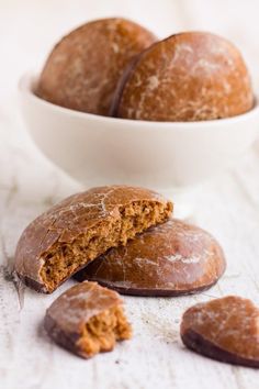 a bowl filled with cookies next to two pieces of bread on top of a table