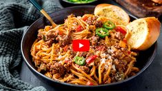 a bowl filled with spaghetti and meat next to bread