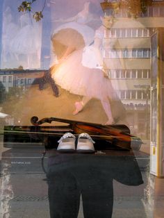 the reflection of a ballerina in a window