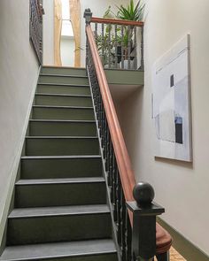 the stairs are painted dark green and there is a potted plant next to it