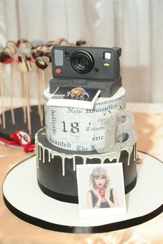 a cake with a camera on top and some candies in the bottom, as well as an image of marilyn monroe