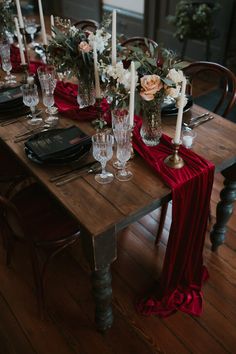 the table is set with candles, flowers and wine glasses for an elegant dinner party