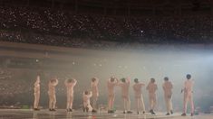 a group of men standing on top of a stage with their hands in the air