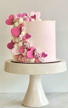 a pink and white cake with hearts on it