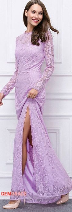 a woman in a long purple dress posing for the camera with her legs slited