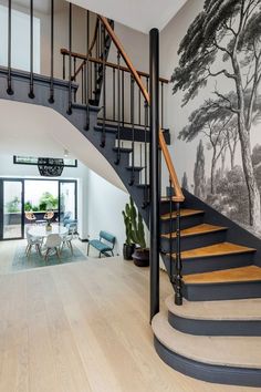 a staircase leading up to a living room with a mural on the wall behind it