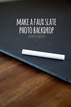 a white pen sitting on top of a black book with the words make a faux slate photo backdrop