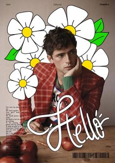 a young man sitting at a table in front of flowers with the word hello written on it