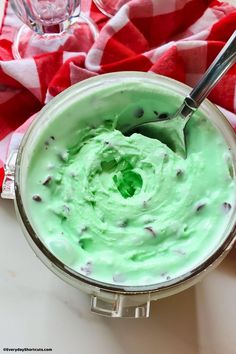 a cup filled with green liquid on top of a table