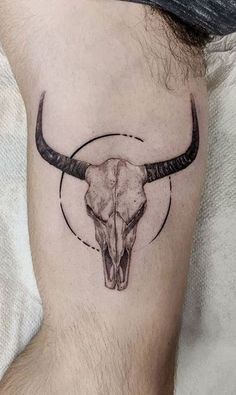 a bull's skull with long horns is shown on the left side of the arm