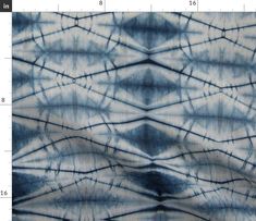 a blue and white tie - dyed fabric with an abstract design on the bottom half