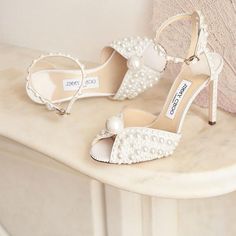 a pair of women's shoes with pearls on the toes and heels are sitting on a table