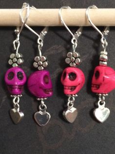 four different colored skulls with hearts hanging from them