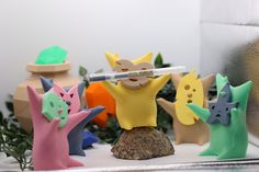 a group of small toy figures on top of a white counter next to a plant