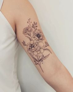 a woman's arm with flowers and leaves tattooed on the left side of her arm