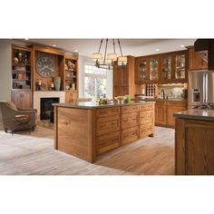 a large kitchen with wooden cabinets and an island in the middle is shown, along with a clock on the wall