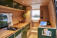 the interior of a tiny home with wood paneling and green cabinets on both sides