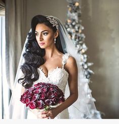 a woman in a wedding dress holding a bridal bouquet and looking at the camera