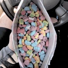 a person holding a bag full of candy hearts