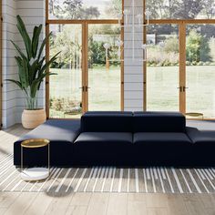 a modern living room with large windows and blue couch