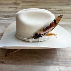 This handmade arrangement of feathers is the perfect way to set your hat apart from the rest. Simply tuck into the band of any hat. Made with a mix of pheasant tail and rooster feathers. Approximately 8 inches long, sizes may vary due to being made with natural materials. Natural Feathers Approx. 8 inches - sizes may vary slightly Tuck into the band of any hat! *Hat not included* CA Residents: Prop 65 Warning ↗️ Creamy Lemon Bars, Phoenix Feather, Rooster Feathers, Feather Hat, Handmade Hat, Hat Band, Hat Sizes, Band, Hats