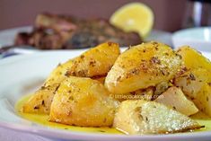 some food is on a white plate with lemons and other foods in the background