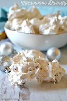 a white bowl filled with whipped cream next to silver ornaments