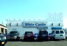 several cars parked in front of a white castle store