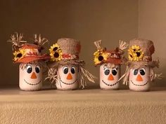 three painted jars with faces and sunflowers on them