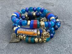 Blues hues; Lapis; Blue Jade; African Krobo beads,; Asanthi glass beads; Brass; wood; Stacking bracelet; Boho; Tribal; Luck; Heart bracelet Price is for one bracelet. Purchase all three for a complete look Style 1: This beautiful boho  bracelet is made of Lapis, Agate, African Krobo beads, and Brass beads. Brass heart charm accentuates the bracelet Style 2: This beautiful boho  bracelet is made of Lapis, Agate, African Krobo beads, Ashanti glass beads and Brass beads. Style 3:This beautiful boho  bracelet is made of Lapis, Jade, Agate, African Krobo beads, Ashanti glass beads and Brass beads. Elephant charm accentuates this bracelet. This bracelet fits wrist size 5 and half inches to 6 and half inches. Please convo with me if you need a different size. Please Note: I do my best to capture Wood Stacking, Boho Bracelets Stack, Krobo Beads, Stacked Bracelets, Beads Style, Blue Jade, Brass Wood, Lapis Blue, Brass Beads