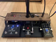 some pedals and other electronic equipment on a wooden floor with wires attached to them