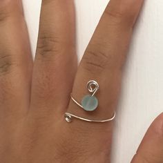 a woman's hand with a ring on it and a sea glass stone in the middle