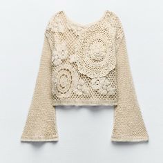 a crocheted top with bell sleeves and flowers