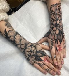 two hands with flowers tattooed on them