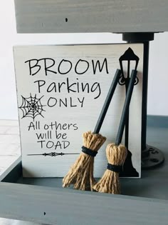 two brooms are placed next to a sign that says broom parking only all others will be toad