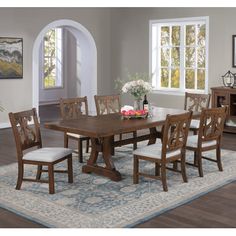 a dining room table with chairs and a rug