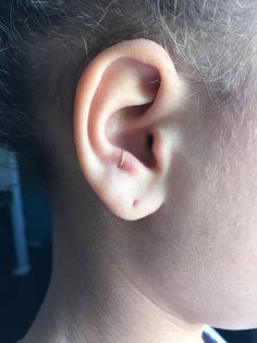 a close up of a person's ear with the top part of their head in view