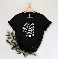 a black t - shirt with white letters and a volleyball on it