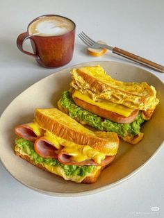 two toasted sandwiches are on a plate next to a cup of coffee