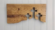 a wooden wall hanging with two pieces of wood cut in to the shape of a map